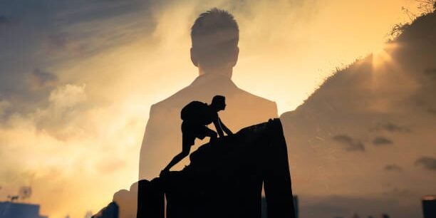 Man feeling determined climbing up a steep mountain side. Leiderschapsontwikkeling Life Business Academy