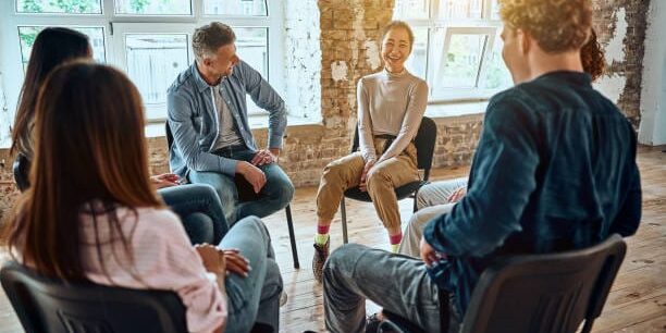 Group therapy session sitting in a circle. Sunbeam background. Selective focus. Teamcoaching Life Business Academy